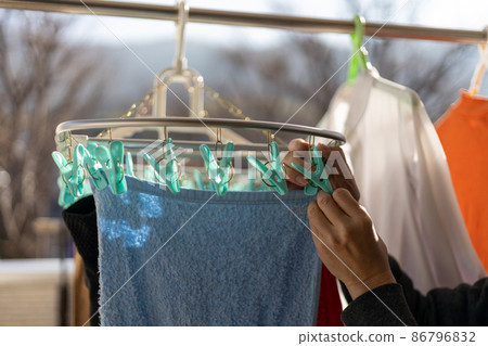 A man is drying the laundry on the balcony A man is drying the laundry on the balcony 86796832