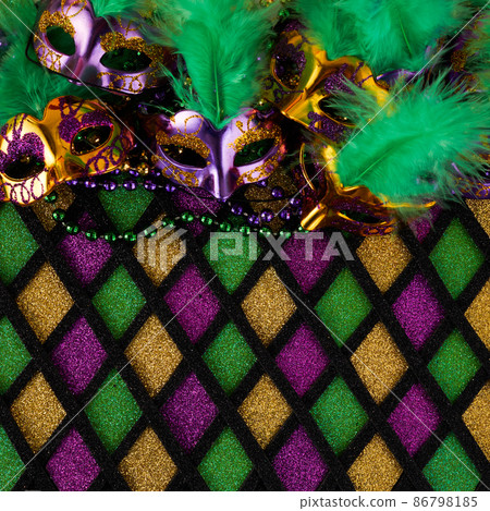 Frame of Mardi Gras Mask and colorful Mardi Gras Beads on diamond shaped background Frame of Mardi Gras Mask and colorful Mardi Gras Beads on diamond shaped background 86798185