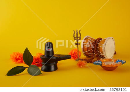 Happy Maha Shivaratri greeting card - Shiva Linga decorated with flowers, trishula, damru and bilva leaves. Hindu festival celebrated of Shiva Lord 86798191