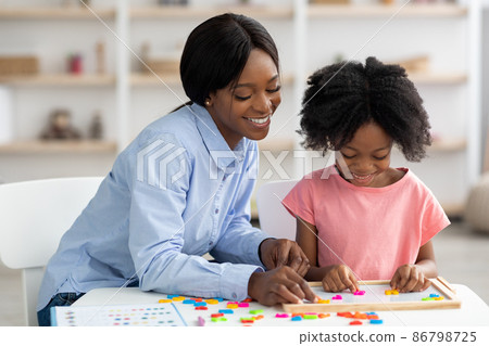 Cheerful pretty african american woman teaching little girl alphabet 86798725