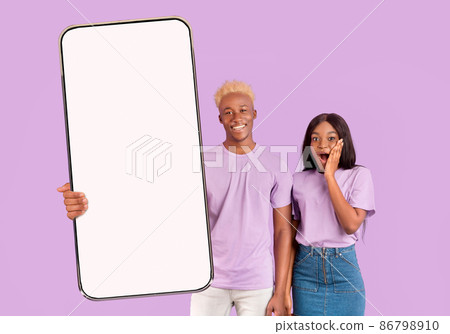 Excited black couple showing white empty smartphone screen Excited black couple showing white empty smartphone screen 86798910