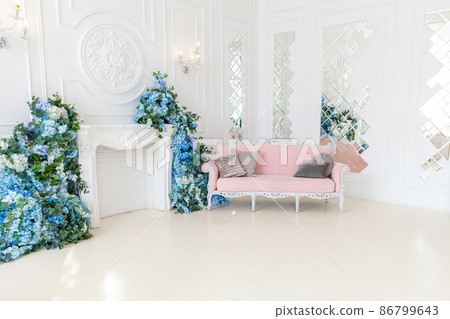 Beautiful luxury classic clean interior living room in white color with pink sofa fireplace flower composition. Bright modern stylish interior living room with furniture in classic minimalist style Beautiful luxury classic clean interior living room in white color with pink sofa fireplace flower composition. Bright modern stylish interior living room with furniture in classic minimalist style 86799643