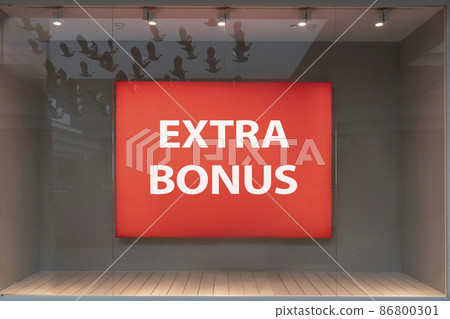extra bonus - the inscription of the word advertising on a shop window behind glass on a red billboard in a boutique extra bonus - the inscription of the word advertising on a shop window behind glass on a red billboard in a boutique 86800301