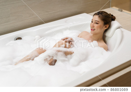 woman relaxing and takes bubble bath in bathtub with foam woman relaxing and takes bubble bath in bathtub with foam 86801089