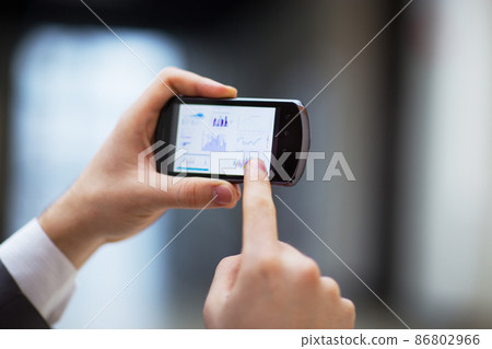 Modern people doing business, graphs and charts being demonstrated on the screen of a phone 86802966