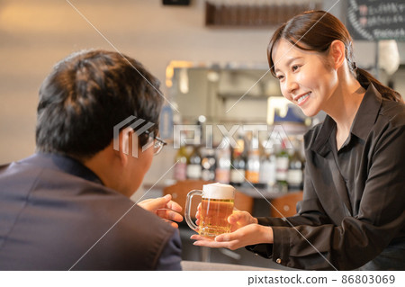 Female staff and male customers serving beer Female staff and male customers serving beer 86803069