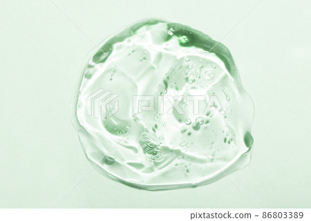 Transparent hyaluronic acid gel drop on a green background. Transparent hyaluronic acid gel drop on a green background. 86803389