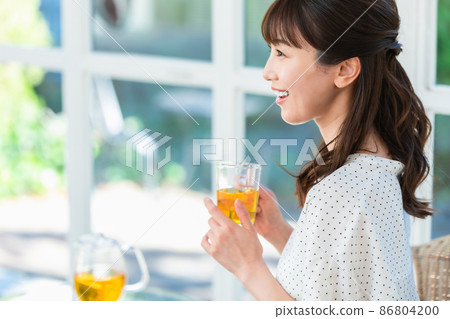 A woman relaxing by drinking tea by the window 86804200