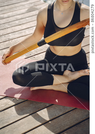 Woman practicing advanced yoga by the water 86804279