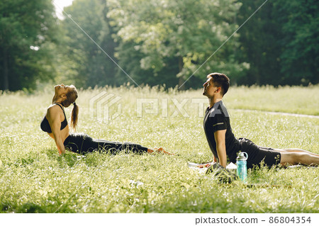Man and woman doing yoga exercises in the park 86804354
