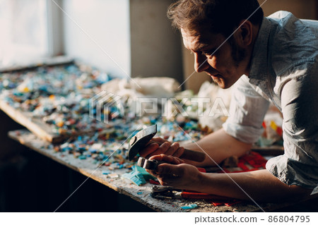 Craftsman male master portrait hold hammer and smalt glass pieces in arm hand for mosaic artwork in workshop. Craftsman male master portrait hold hammer and smalt glass pieces in arm hand for mosaic artwork in workshop. 86804795