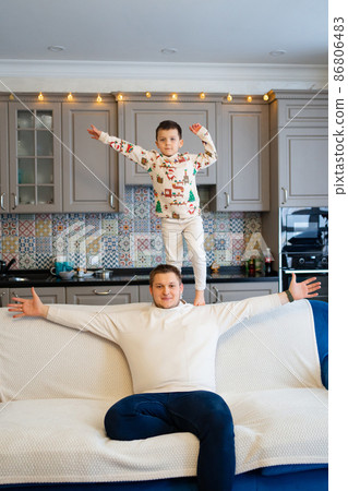 cheerful and happy dad and son fool around and play at home. family happiness. 86806483