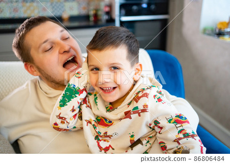 cheerful and happy dad and son fool around and play at home. family happiness. cheerful and happy dad and son fool around and play at home. family happiness. 86806484