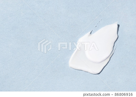 Smear of cosmetic cream on a blue background. Smear of cosmetic cream on a blue background. 86806916