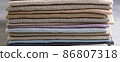 A pile of four folded dull-colored natural linen fabric 86807318