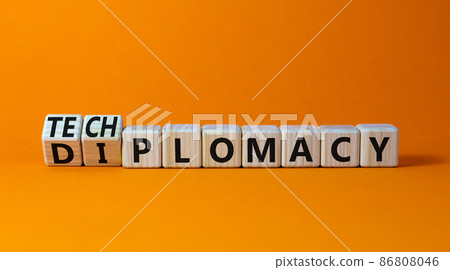Diplomacy or techplomacy symbol. Turned wooden cubes and changed the concept word diplomacy to techplomacy. Beautiful orange background, copy space. Business, diplomacy or techplomacy concept. Diplomacy or techplomacy symbol. Turned wooden cubes and changed the concept word diplomacy to techplomacy. Beautiful orange background, copy space. Business, diplomacy or techplomacy concept. 86808046