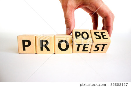 Propose instead protest symbol. Businessman turns wooden cubes, changes the word 'protest' to 'propose'. Beautiful white table, white background. Business, protest or propose concept. Copy space. 86808127