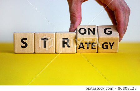 Strong strategy symbol. Businessman turns wooden cubes with words 'strong strategy'. Beautiful yellow table, white background, copy space. Business and strong strategy concept. Strong strategy symbol. Businessman turns wooden cubes with words 'strong strategy'. Beautiful yellow table, white background, copy space. Business and strong strategy concept. 86808128