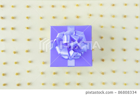 Purple gift box with satin ribbon bow on the yellow mimosa flowers background 86808334