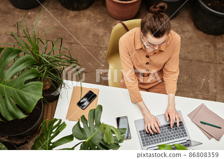 Above angle of young confident businesswoman typing on laptop keyboard 86808359