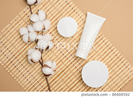 jar and empty white plastic tubes for cosmetics on a beige background. Packaging for cream, gel, serum, advertising and product promotion, mock up, top view jar and empty white plastic tubes for cosmetics on a beige background. Packaging for cream, gel, serum, advertising and product promotion, mock up, top view 86808502