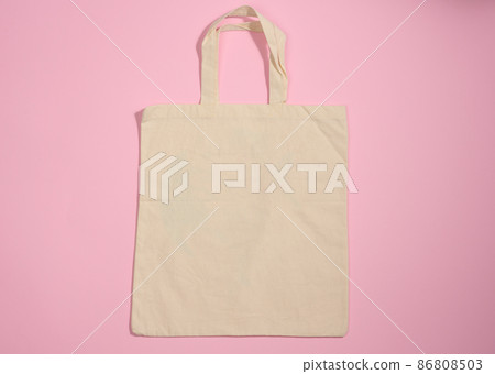 empty linen eco friendly beige canvas tote bag for branding on a pink background. Clear reusable bag for groceries, mock up. Flat lay empty linen eco friendly beige canvas tote bag for branding on a pink background. Clear reusable bag for groceries, mock up. Flat lay 86808503