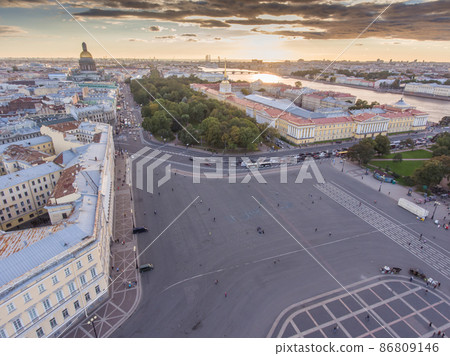 Aerial view of Palace Square at sunset, the golden dome of cathedral of St. Isaac, spire of Admiralty building, the Winter Palace, long shadows, moody clouds, embankment of Neva river Aerial view of Palace Square at sunset, the golden dome of cathedral of St. Isaac, spire of Admiralty building, the Winter Palace, long shadows, moody clouds, embankment of Neva river 86809146