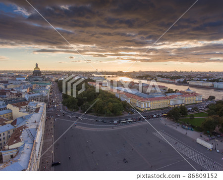 Aerial view of Palace Square at sunset, the golden dome of cathedral of St. Isaac, spire of Admiralty building, the Winter Palace, long shadows, moody clouds, embankment of Neva river Aerial view of Palace Square at sunset, the golden dome of cathedral of St. Isaac, spire of Admiralty building, the Winter Palace, long shadows, moody clouds, embankment of Neva river 86809152