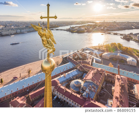 Aerial view of golden Angel and Cross on spike of the Peter and Paul cathedral in Saint Petersburg at sunset, frozen Neva River, sunny frosty day, Winter Palace, Admiralty, Rostral columns 86809155
