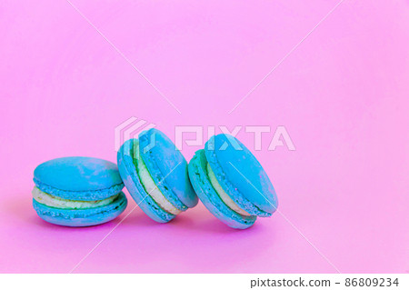 Sweet almond colorful unicorn blue macaron or macaroon dessert cake isolated on trendy pink pastel background. French sweet cookie. Minimal food bakery concept. Copy space Sweet almond colorful unicorn blue macaron or macaroon dessert cake isolated on trendy pink pastel background. French sweet cookie. Minimal food bakery concept. Copy space 86809234