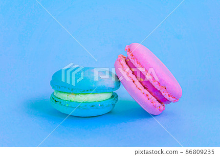 Sweet almond colorful unicorn blue pink macaron or macaroon dessert cake isolated on trendy blue pastel background. French sweet cookie. Minimal food bakery concept. Copy space Sweet almond colorful unicorn blue pink macaron or macaroon dessert cake isolated on trendy blue pastel background. French sweet cookie. Minimal food bakery concept. Copy space 86809235