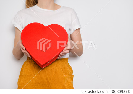 Woman holding a big red box in shape of a heart. Trendy video banner for Valentines Day, International Womens Day or mothers day 86809858