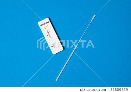 Hand holding negative test result by using rapid test device for COVID-19 isolated on blue background. Diagnosis Corona virus infection at home 86809859