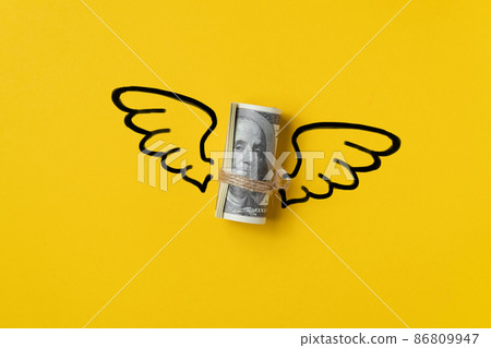 Roll of us dollar money with wings. 86809947