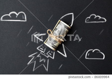 Rocket with a roll of dollars. The concept of financial success and wealth growth in business. Rocket with a roll of dollars. The concept of financial success and wealth growth in business. 86809964
