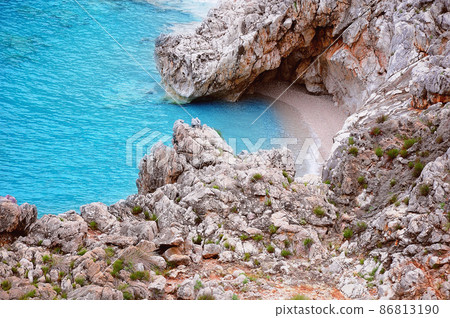 Colorful cliffs by the water edge. Natural reserve Zingaro. Sicily. Colorful cliffs by the water edge. Natural reserve Zingaro. Sicily. 86813190