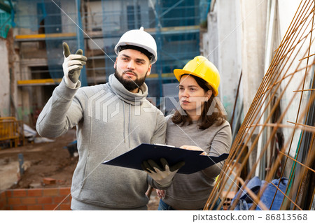 Engineers discussing blueprint at construction site Engineers discussing blueprint at construction site 86813568