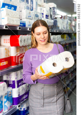 girl choosing pack of toilet paper girl choosing pack of toilet paper 86813592