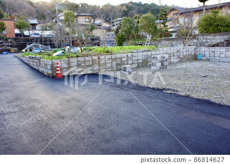 Build a parking space by paving the vacant lot with asphalt 86814627