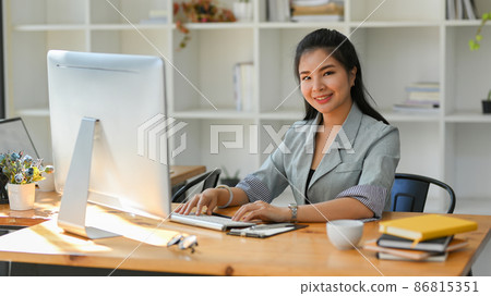 Female boss sits at her private office desk and working on pc computer. 86815351