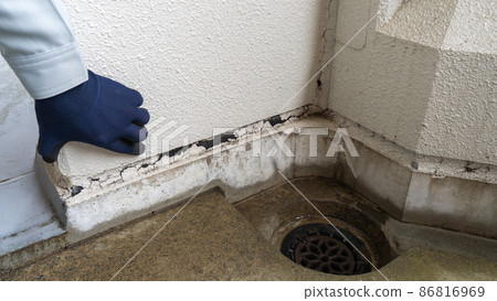 Workers inspecting deterioration of outer wall joints and clogging of drains 86816969