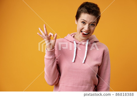 Young pretty woman over isolated yellow background showing ok sign 86818388