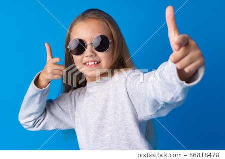 Little fashion girl in sunglasses against blue background 86818478