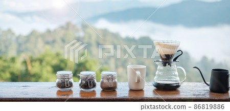 arabica coffee brewing by Vintage coffee drip equipment set on wooden table in the morning with mountain and nature background arabica coffee brewing by Vintage coffee drip equipment set on wooden table in the morning with mountain and nature background 86819886
