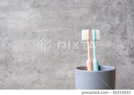 Set of Toothbrushes in cup on wall background at bathroom. World oral health day and free dental day concept Set of Toothbrushes in cup on wall background at bathroom. World oral health day and free dental day concept 86819893