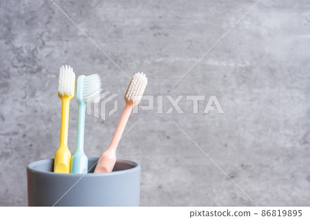 Set of Toothbrushes in cup on wall background at bathroom. World oral health day and free dental day concept Set of Toothbrushes in cup on wall background at bathroom. World oral health day and free dental day concept 86819895