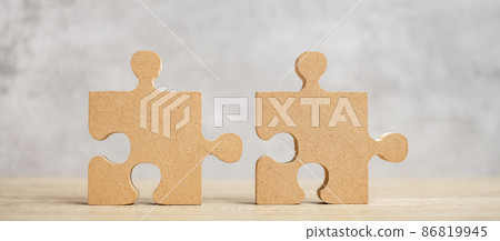 connecting couple puzzle piece, wood jigsaw on table. Business solutions, mission, success, goals and strategy concepts connecting couple puzzle piece, wood jigsaw on table. Business solutions, mission, success, goals and strategy concepts 86819945
