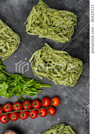 Raw italian pasta, on black dark stone table background, top view flat lay 86820315