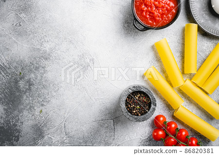 Cannelloni preparations. Minimal concept, on gray stone table background, top view flat lay, with copy space for text 86820381