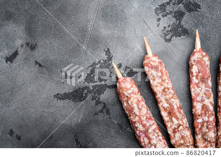 Raw shish kebab skewers, on gray stone table background, top view flat lay, with copy space for text Raw shish kebab skewers, on gray stone table background, top view flat lay, with copy space for text 86820417